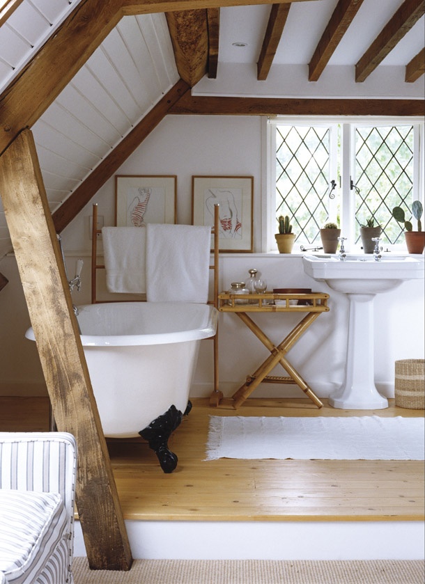 Freestanding roll top bath next to pedestal washbasin in country style bathroom